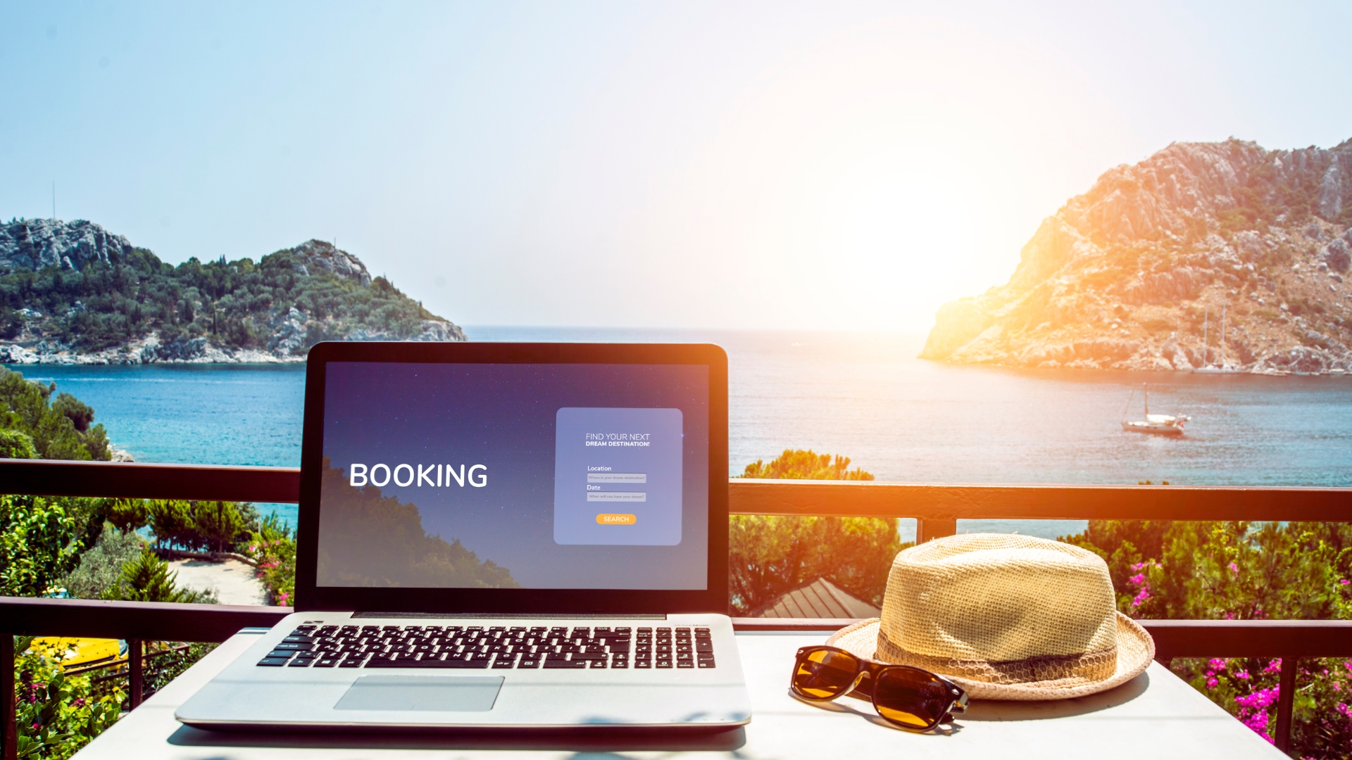 Laptop on a hotel with amazing beach view displaying OTA (Online Travel Agency) interface