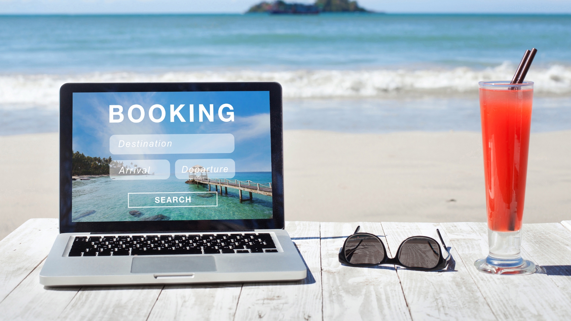 Laptop on a beautiful beach displaying OTA (Online Travel Agency) interface