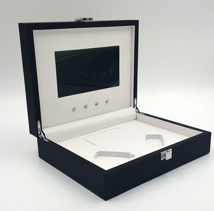 An interactive black box of video brochures equipped with a volume button for enhanced user engagement