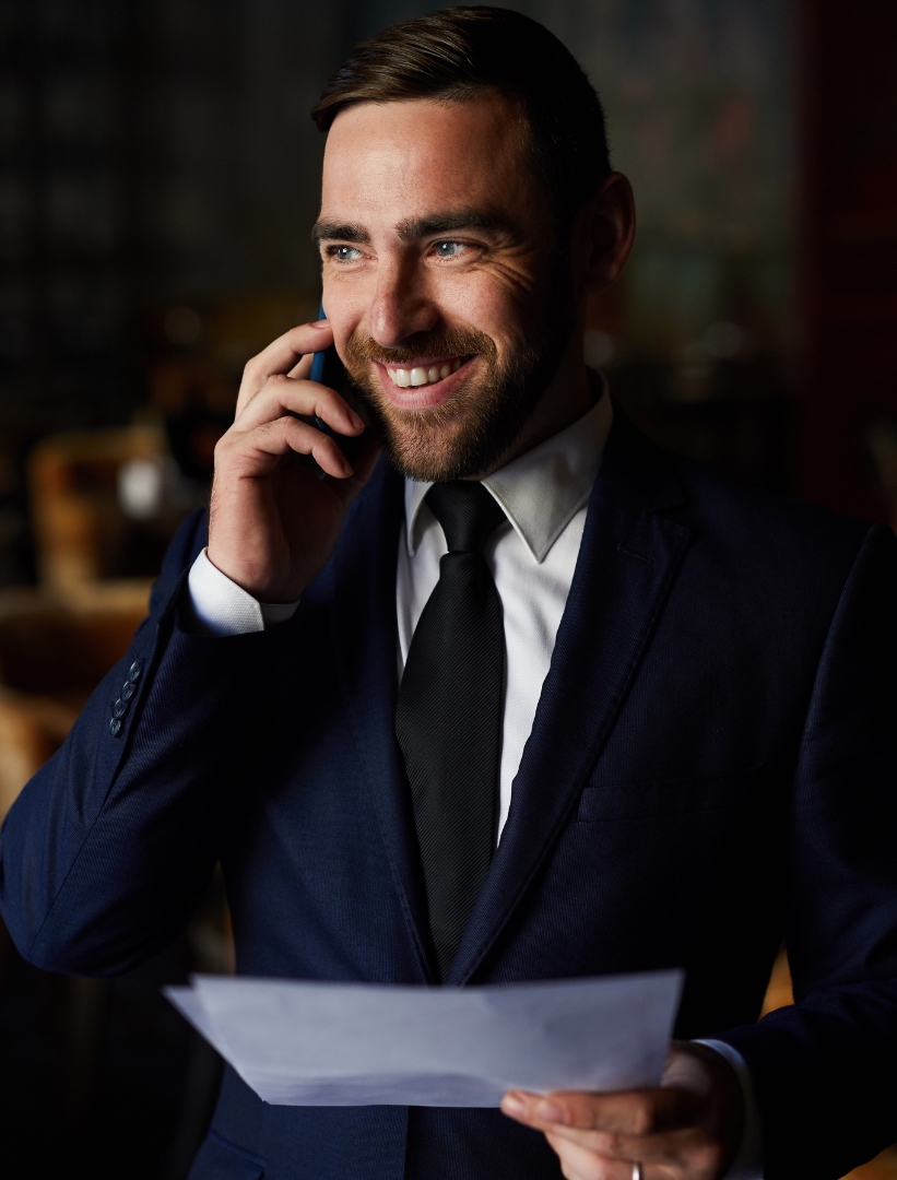 A business man with dark blue suit and white shirt smile while calling to someone about his social media plan template for restaurant and cafe