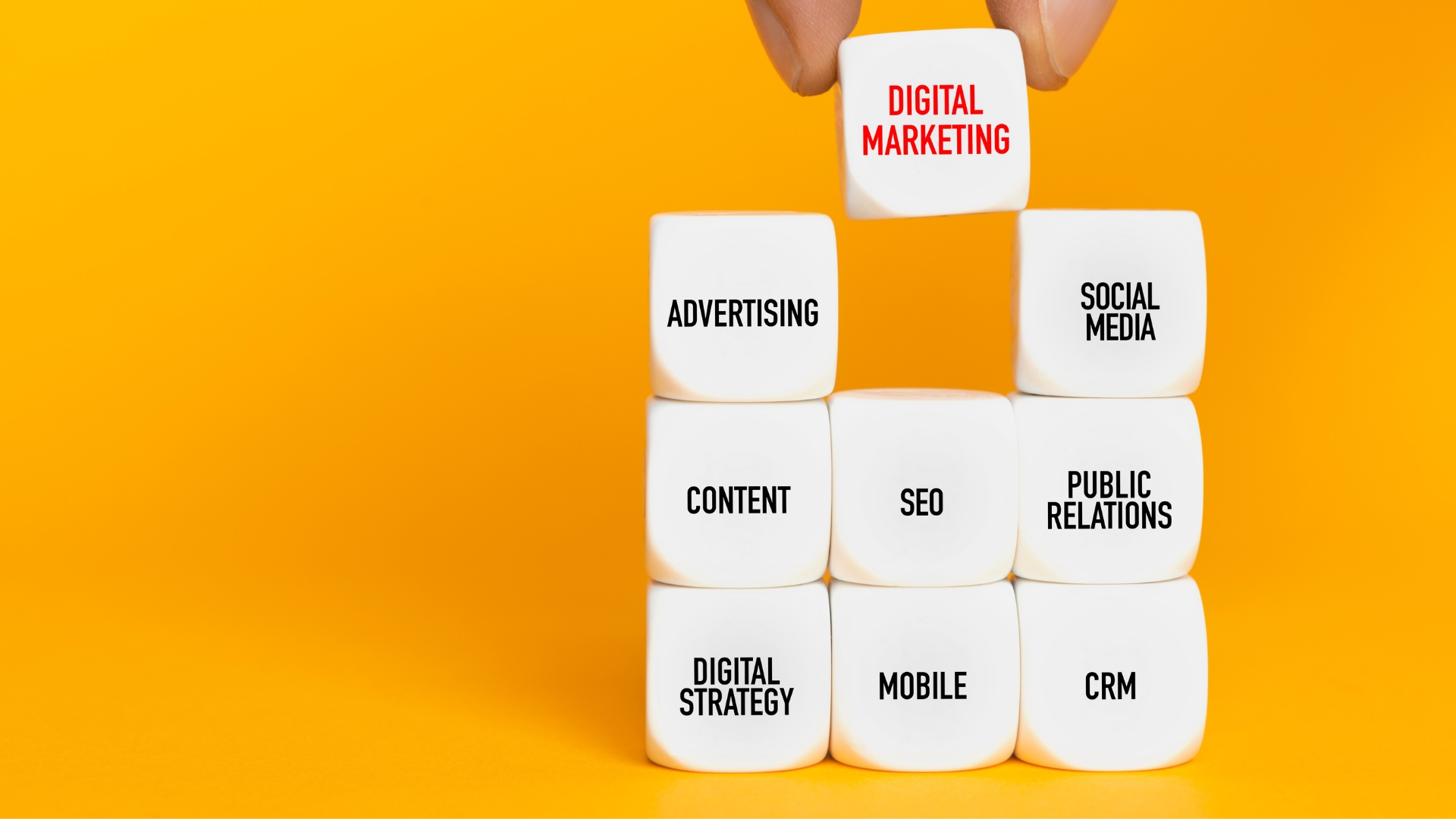 Stack of nine white dice with writing of nine most essential strategies in digital marketing