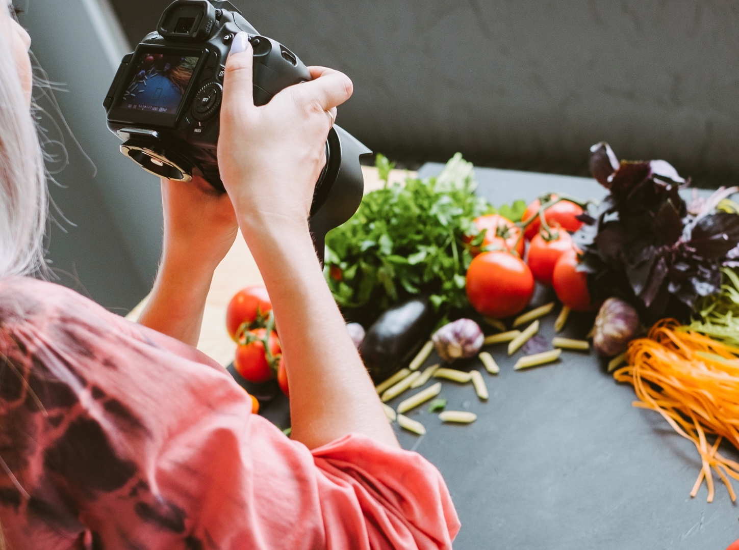 Two-hands-of-silver-hair-female-mode-hold-camera-and-take-a-picture-of-food-ingredients-in-her-studio