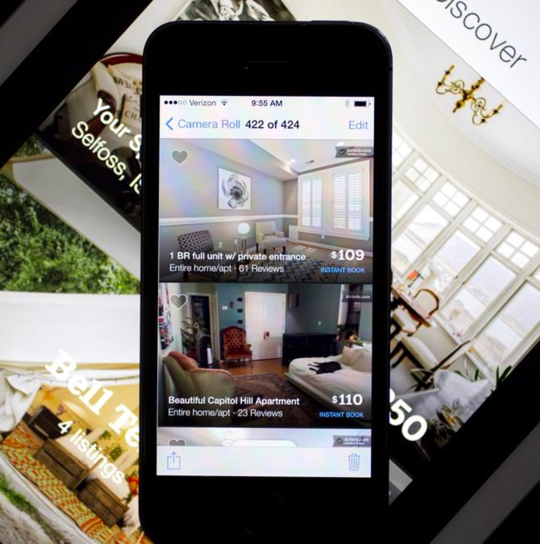 a black phone displays airbnb setup service process with airbnb website as the background