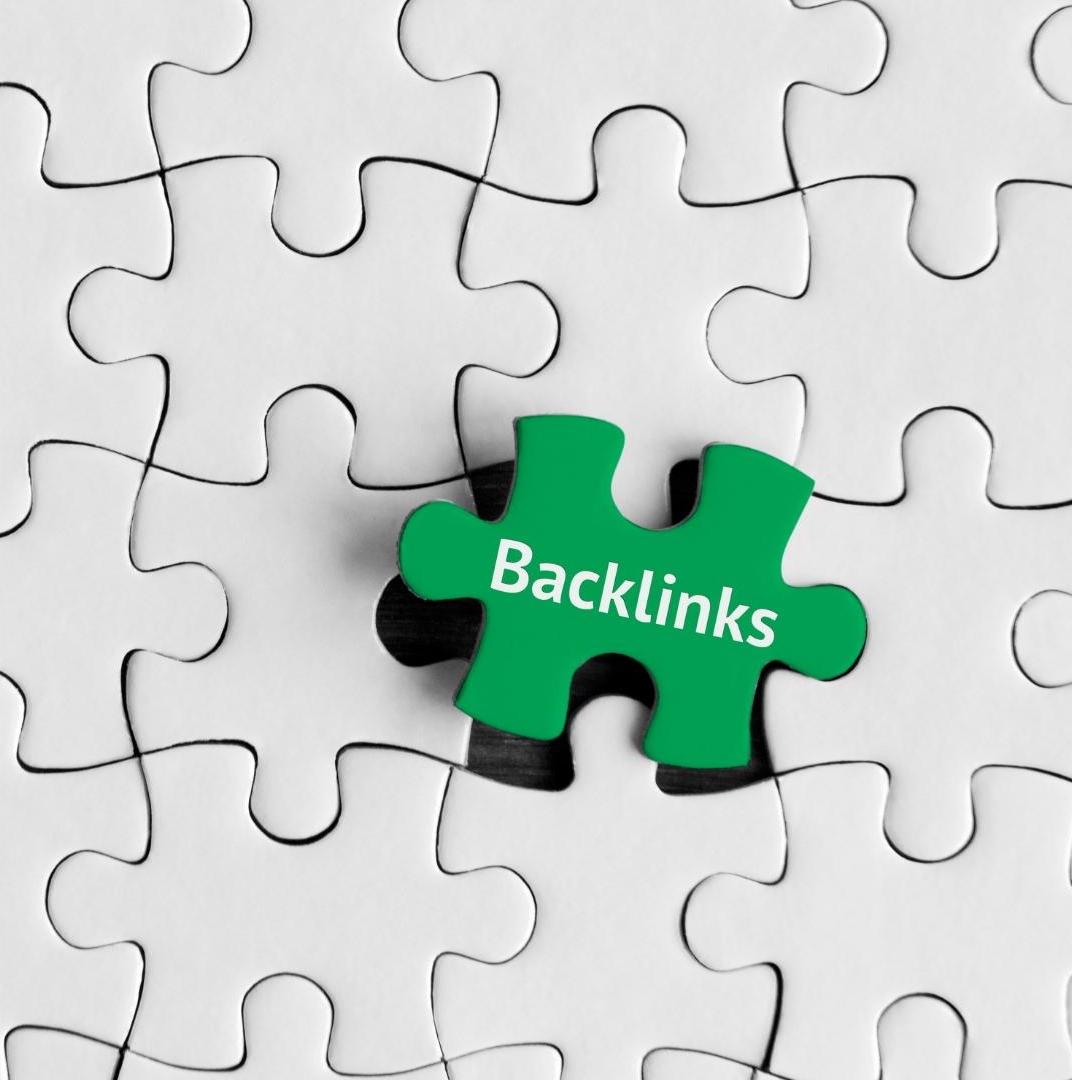 a green puzzle with a text "Backlinks" on it in the middle of white puzzles as a symbolic of strategic positive link building