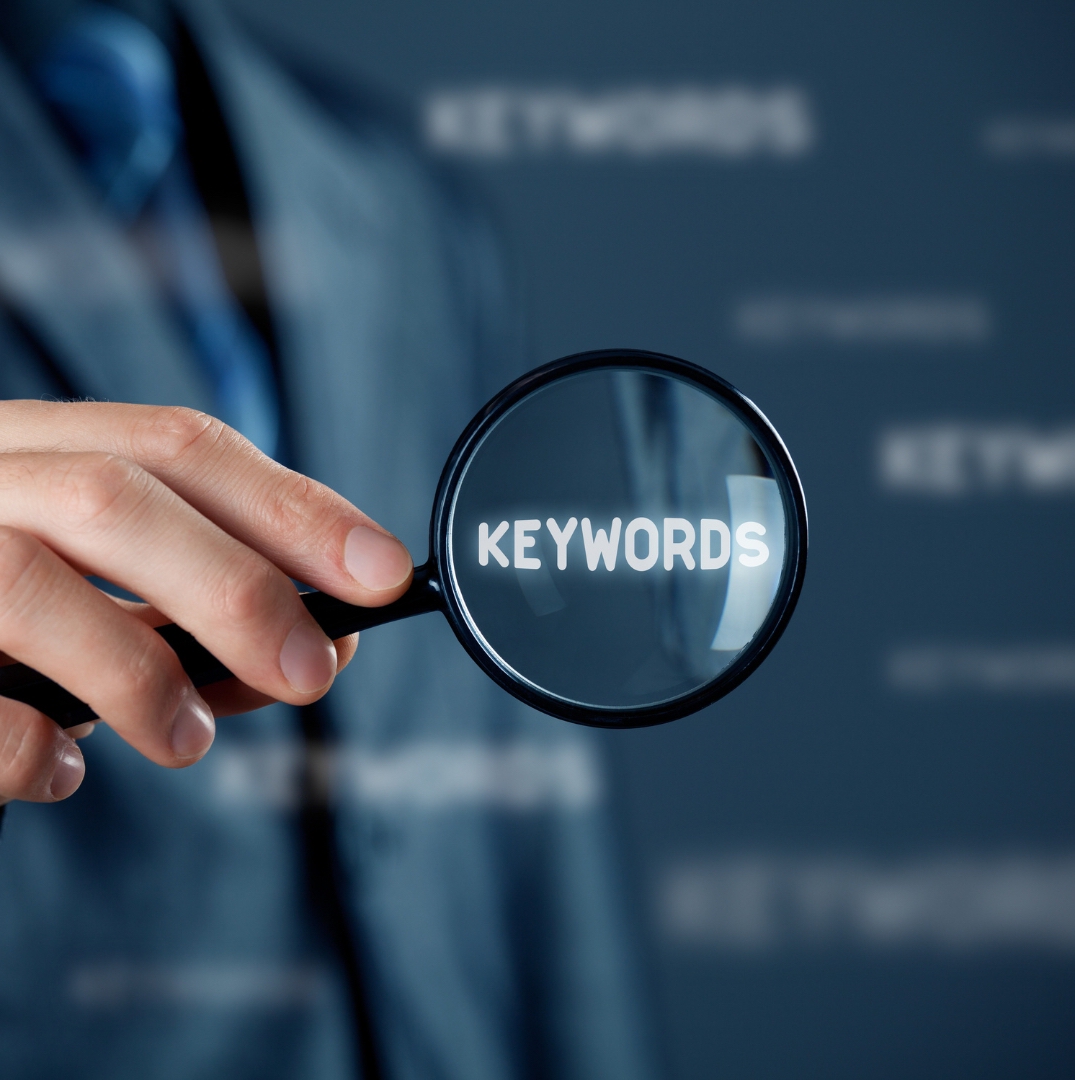 a professional man holds a lup with keyword inside it as a symbolize SEO audit & keyword research