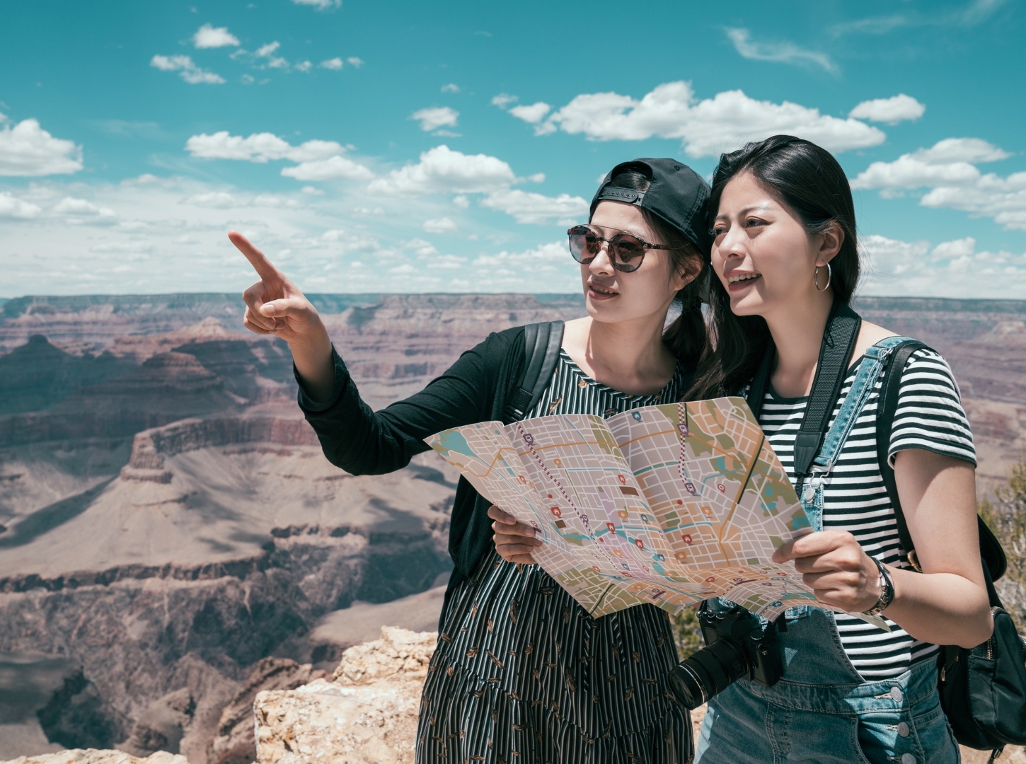 two-asian-girls-at-green-canyon-bring-map-and-dslr-camera